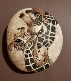 two giraffes painted on a rock with another animal in the middle and one behind it