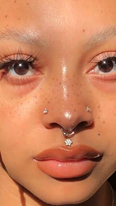 a woman with piercings on her nose and nose ring in front of her face