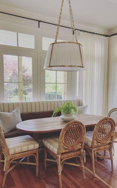 a dining room table with four chairs and a light fixture hanging over it's head