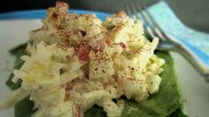 a white plate topped with lettuce covered in toppings next to a fork