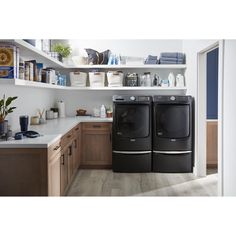 the front load washer and dryer are next to each other in this kitchen