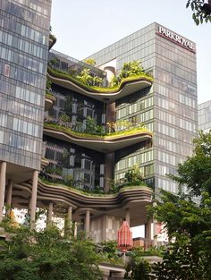 a tall building with many balconies and plants growing on it