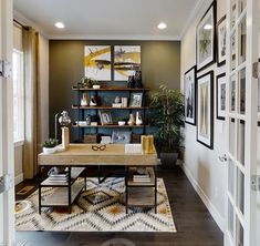 a living room filled with lots of furniture and pictures on the wall next to a desk