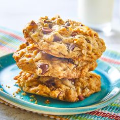 three cookies stacked on top of each other on a plate next to a glass of milk