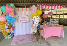 an ice cream stand with balloons and decorations