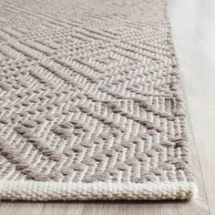 an area rug on the floor with white and gray colors, including lines in the middle