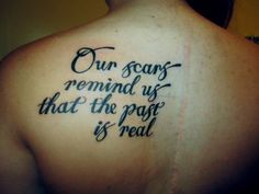 a person with a tattoo on their back saying our scars remind us that the past is real