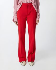 Elegant high-waisted women's trousers in stretch crepe fabric. The leg is characterised by a close-fitting line down to the knee, which widens as it proceeds to the bottom, with French pockets at the hips and a central pleat at both front and back. Zip and covered hook fastening. Fitted Flare Pants With Pressed Crease, Red Full-length Elastane Pants, Full-length Red Elastane Pants, Full Length Red Pants, Tailored Classic Red Pants, Classic Tailored Red Pants, Red Elastane Pants For Work, Red Elastane Trousers, Red Wide Leg Elastane Pants