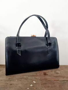 Description: Navy Blue Ackery Handbag. Made in England. Like New Condition.  Measurements: WIDTH: 31cm,  HEIGHT: 21cm Classic Shopping Bag With Hasp Closure, Classic Shopping Bag With Secure Closure, Classic Blue Rectangular Box Bag, Classic Tote Bag With Hasp Closure, Blue Office Bag With Hasp Closure, Classic Blue Shoulder Box Bag, Vintage Blue Double Handle Bag, Vintage Blue Double Handle Shoulder Bag, Vintage Blue Top Handle Satchel