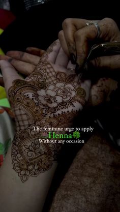 the henna is being applied to someone's hand with an inscription on it