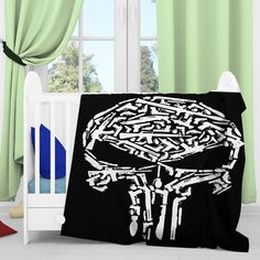 a black blanket with a white skull on it in front of a crib and green curtains