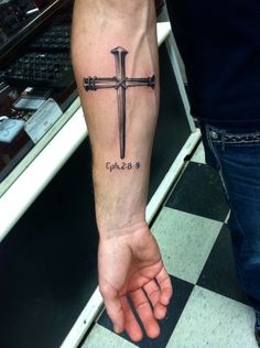 a person with a cross tattoo on their arm