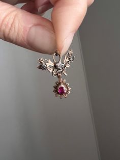 ABOUT: Beautiful floral pendant in 10k Rose gold with a pear shaped ruby in a closed back teardrop dangle, and a leaf and floral top set with rose cut diamonds. No hallmarks but tests at 10k and the collets are silver as was customary to set diamonds in a white metal. SIZE & MEASUREMENTS: 18mm by 21mm.  It weighs 1.95 grams. Antique props, boxes, chains etc. not included. IMPORTANT CONDITION NOTES: All my pieces are preowned and in estate condition.  I think the loop is a later addition, the piece may have come from something else?  Some nicks and inclusions to the ruby and the diamonds are darker in color from the closed back.  Antique patina but still beautiful and wearable. Please note this is not a mint condition piece. Thanks so much for looking at my items! I'd be delighted if you'd Rose Gold Teardrop Ruby Jewelry, Antique Props, Antique Pendant, Nose Jewelry, Floral Pendant, Flower Leaf, Antique Roses, Jewel Box, Ruby Rose