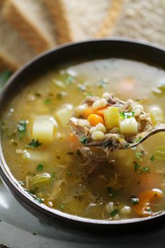 a spoon full of soup with meat and vegetables