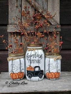 three mason jars with pumpkins painted on them