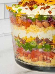 a layered salad in a glass dish on a counter