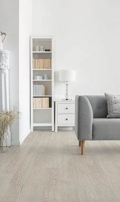 a living room with white walls and wood flooring on the floors is pictured in this image