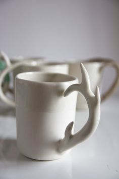 two white cups with antlers on them sitting next to each other