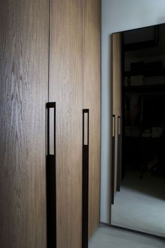 an empty room with wooden doors and black handles