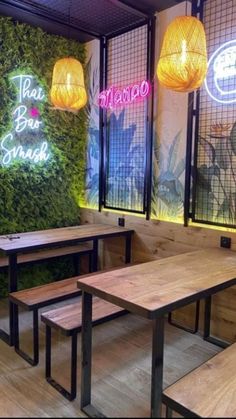 a restaurant with wooden tables and benches in front of a wall that has plants growing on it