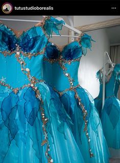 the dress is blue and has gold trims on it, along with other dresses