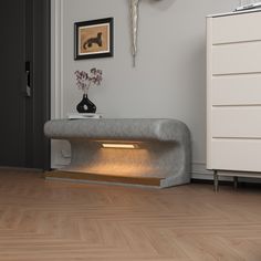 a living room with white walls and wooden floors is lit up by a light that has been placed on the wall