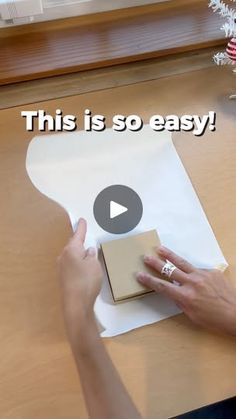 a person is making something with paper on a wooden table that says, this is so easy