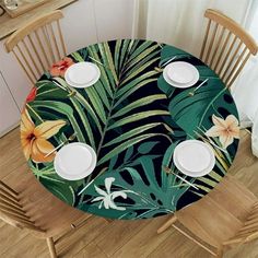 the table is set with plates and place settings for four to six people, which are surrounded by tropical leaves