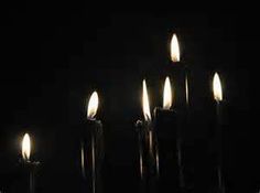 five candles lit in the dark on a black background