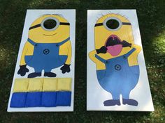 two cornhole game boards that have been painted to look like minion characters