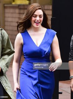 a woman in a blue dress is walking down the street