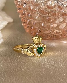 The Irish Promise Ring a traditional Claddagh ring was a design from love. Especially for the Irish lovers! Perfect for a queen and stacks well.This Beautiful ring is 18kt gold plated silver with emerald cubic zirconia and faux pearls. Yellow Gold Jeweled Rings As Gifts, Yellow Gold Rings With Jewels For Gift, Gold Plated May Birthstone Ring, Fine Jewelry Rings For Anniversary With Jewels, Fine Jewelry Rings For Anniversary, Anniversary Fine Jewelry Rings With Jewels, Gold Jewelry For May Birthstone Promise, Hallmarked Emerald Ring For Promise - May Birthstone, Emerald Birthstone Ring For Promise