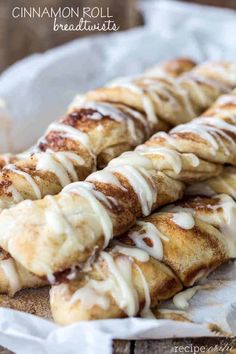 cinnamon roll braids with icing sitting on top of a white paper wrapper