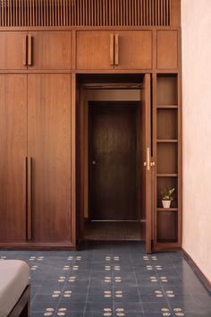 an empty room with wooden cabinets and a bed on the floor in front of it