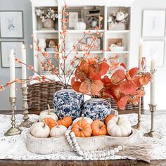 a table topped with vases filled with pumpkins and other fall decorating items