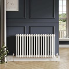 a white radiator sitting on top of a wooden floor