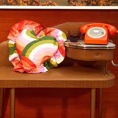 an orange phone sitting on top of a wooden chair