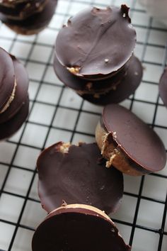 chocolate covered cookies sitting on top of a cooling rack with one broken in the middle