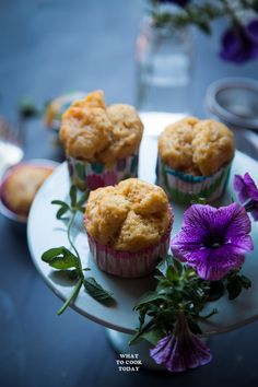 three muffins on a plate with purple flowers