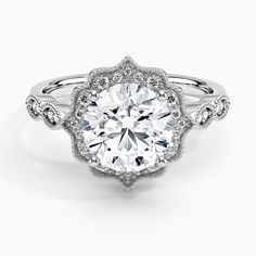 a white gold engagement ring with an intricate flower design