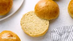 some bread rolls are sitting on a white counter top next to plates and napkins