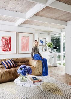 a woman sitting on top of a couch in a living room