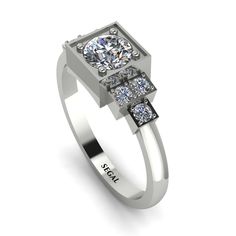 a white gold ring with three diamonds on top and the words segel jewelry written below it