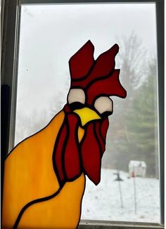 a close up of a stained glass window with a rooster on it's face