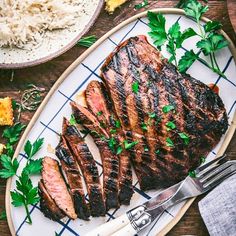 grilled steak on a plate with parsley garnishes and white rice