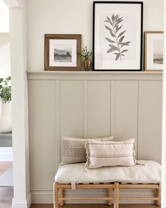 a bench with pillows and pictures on the wall