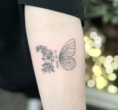 a small butterfly and flowers tattoo on the arm