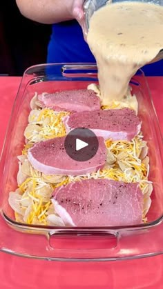 someone pouring sauce on some meats in a glass casserole dish with other food items