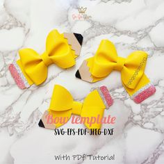 three yellow bows with sequins on them sitting on a marble counter top next to each other