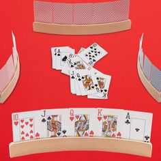 playing cards are laid out on top of each other and placed in front of a red background